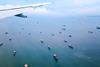 aircraft wing over ocean with a fleet of ships