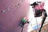 A worker using the InfraLaser rust and coating removal system on a ship's hull