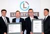 DNV GL’s Matthias Ritters, regional manager Germany (left) and Frank Hensel, key account manager at the classification society (right) hand over the ISO certificates to Liberty One’s managing director Dietrich Schulz (second from right) and Capt...