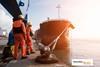 Engineers standing on a dock with a ship alongside