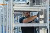 The image shows a technician in the process of assembling The Switch DC-Hub cabinets.