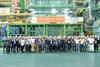 The image shows a group shot of WinGD and Hanwha Group employees in front of the LNG carrier engine