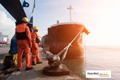 Engineers standing on a dock with a ship alongside