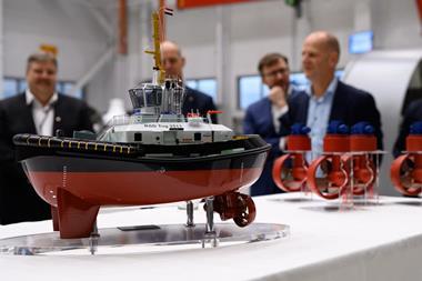 Miniature model of a Damen RSD Tug 2513 with five men in the background