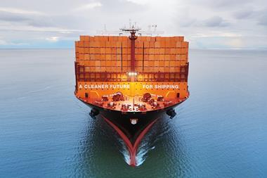 Container ship at sea full of orange containers saying 'A CLEANER FUTURE FOR SHIPPING'