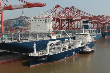 SIPG's LNG bunkering vessel alongside a containership with cranes dockside