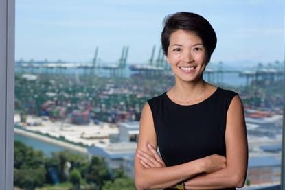 The photo shows Lynn Loo smiling for the camera in front of a port back drop