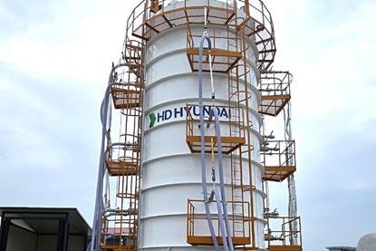 Workers in white hard hats in front of an HD KSOE LH2 vacuum tank