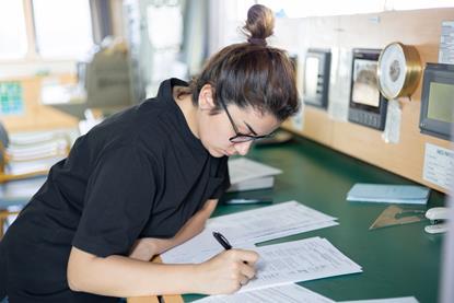 The image shows a worker looking at shipping data
